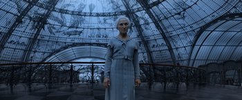 Movie still from “Fantastic Beasts: The Crimes of Grindelwald” (2018), directed by David Yates – An old woman standing in front of a large glass dome; Medium shot, Low angle