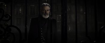 Movie still from “Fantastic Beasts: The Crimes of Grindelwald” (2018), directed by David Yates – An older man in a suit and beard; Close Up shot, Low angle