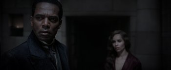 Movie still from “Fantastic Beasts: The Crimes of Grindelwald” (2018), directed by David Yates – A man and a woman standing next to each other in a dark room; Close Up shot, Over the shoulder angle