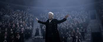 Movie still from “Fantastic Beasts: The Crimes of Grindelwald” (2018), directed by David Yates – An old man standing in front of a crowd of people; Medium shot, Low angle
