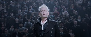 Movie still from “Fantastic Beasts: The Crimes of Grindelwald” (2018), directed by David Yates – A man with white spiky hair standing in front of a crowd; Close Up shot, Low angle