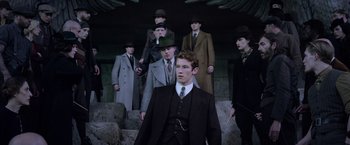 Movie still from “Fantastic Beasts: The Crimes of Grindelwald” (2018), directed by David Yates – A group of men wearing suits and hats; Medium shot, Low angle