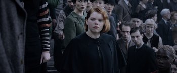Movie still from “Fantastic Beasts: The Crimes of Grindelwald” (2018), directed by David Yates – A group of people standing in a crowd of men and women; Close Up shot, Over the shoulder angle
