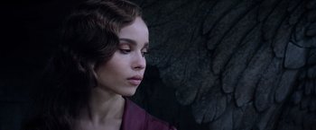 Movie still from “Fantastic Beasts: The Crimes of Grindelwald” (2018), directed by David Yates – A beautiful young woman with a purple shirt and brown hair; Close Up shot, Over the shoulder angle
