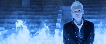 Movie still from “Fantastic Beasts: The Crimes of Grindelwald” (2018), directed by David Yates – A man standing in front of a fire and a brick wall; Close Up shot, High angle