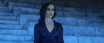 Movie still from “Fantastic Beasts: The Crimes of Grindelwald” (2018), directed by David Yates – A woman in a blue dress standing in front of a staircase; Medium shot, High angle