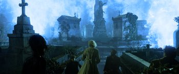 Movie still from “Fantastic Beasts: The Crimes of Grindelwald” (2018), directed by David Yates – A group of people standing in front of a large statue; Wide shot, Low angle
