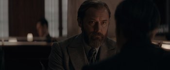 Movie still from “Fantastic Beasts: The Secrets of Dumbledore” (2022), directed by David Yates – A man in a suit and a tie looking to his left; Close Up shot, Over the shoulder angle