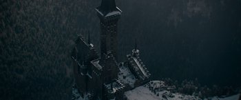 Movie still from “Fantastic Beasts: The Secrets of Dumbledore” (2022), directed by David Yates – An aerial view of a castle with snow on the ground; Extreme Wide shot, High angle