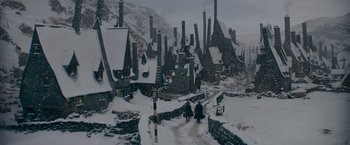 Movie still from “Fantastic Beasts: The Secrets of Dumbledore” (2022), directed by David Yates – Two people walking down a snow covered road; Extreme Wide shot, High angle