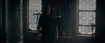 Movie still from “Fantastic Beasts: The Secrets of Dumbledore” (2022), directed by David Yates – A woman standing in a dark room with a window; Medium shot, Low angle