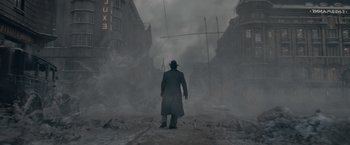 Movie still from “Fantastic Beasts: The Secrets of Dumbledore” (2022), directed by David Yates – A man standing in the middle of a street; Wide shot, Low angle