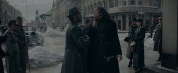 Movie still from “Fantastic Beasts: The Secrets of Dumbledore” (2022), directed by David Yates – Two men in coats and hats talking to each other on a snowy day; Medium shot, Over the shoulder angle