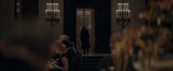 Movie still from “Fantastic Beasts: The Secrets of Dumbledore” (2022), directed by David Yates – A woman standing in front of a door in a room; Wide shot, Over the shoulder angle