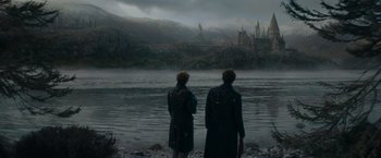 Movie still from “Fantastic Beasts: The Secrets of Dumbledore” (2022), directed by David Yates – Two people standing on the shore of a body of water; Extreme Wide shot, Low angle
