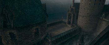 Movie still from “Fantastic Beasts: The Secrets of Dumbledore” (2022), directed by David Yates – An aerial view of an old building with a balcony; Extreme Wide shot, High angle
