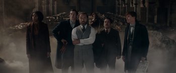 Movie still from “Fantastic Beasts: The Secrets of Dumbledore” (2022), directed by David Yates – A group of men standing next to each other in a room; Medium shot, Low angle