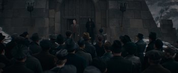Movie still from “Fantastic Beasts: The Secrets of Dumbledore” (2022), directed by David Yates – A group of people standing in front of a building; Wide shot, Over the shoulder angle