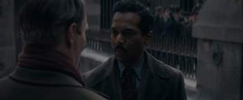 Movie still from “Fantastic Beasts: The Secrets of Dumbledore” (2022), directed by David Yates – A man in a suit and tie talking to another man in a suit and tie; Close Up shot, Over the shoulder angle