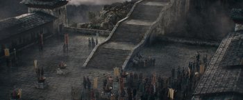 Movie still from “Fantastic Beasts: The Secrets of Dumbledore” (2022), directed by David Yates – A group of people standing around a stone staircase; Extreme Wide shot, High angle
