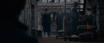 Movie still from “Fantastic Beasts: The Secrets of Dumbledore” (2022), directed by David Yates – Two men are standing in the middle of an alley; Wide shot, High angle