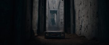 Movie still from “Fantastic Beasts: The Secrets of Dumbledore” (2022), directed by David Yates – An old suitcase in the middle of an alleyway; Extreme Wide shot, High angle