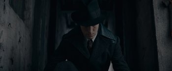 Movie still from “Fantastic Beasts: The Secrets of Dumbledore” (2022), directed by David Yates – A man wearing a hat and a coat; Close Up shot, High angle