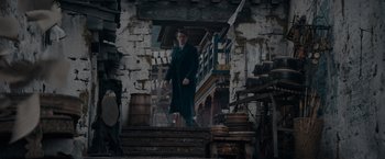 Movie still from “Fantastic Beasts: The Secrets of Dumbledore” (2022), directed by David Yates – A man standing on steps in front of an old building; Wide shot, High angle