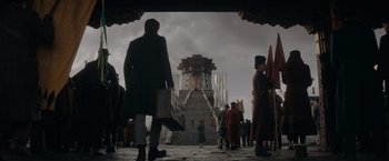 Movie still from “Fantastic Beasts: The Secrets of Dumbledore” (2022), directed by David Yates – A group of people standing on a stone walkway; Extreme Wide shot, Low angle