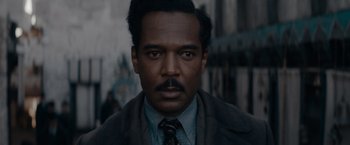 Movie still from “Fantastic Beasts: The Secrets of Dumbledore” (2022), directed by David Yates – A person wearing a suit and tie; Close Up shot, High angle