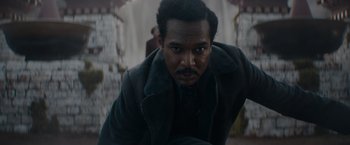 Movie still from “Fantastic Beasts: The Secrets of Dumbledore” (2022), directed by David Yates – A man in a black coat is looking at the camera; Close Up shot, High angle