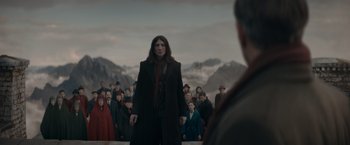 Movie still from “Fantastic Beasts: The Secrets of Dumbledore” (2022), directed by David Yates – A man standing in front of a group of people; Wide shot, Over the shoulder angle