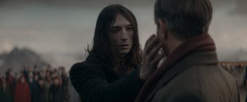 Movie still from “Fantastic Beasts: The Secrets of Dumbledore” (2022), directed by David Yates – A man with long black hair looking into a mirror; Close Up shot, Over the shoulder angle