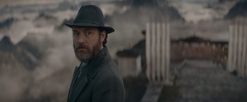 Movie still from “Fantastic Beasts: The Secrets of Dumbledore” (2022), directed by David Yates – A man with a beard wearing a coat and a hat; Close Up shot, Low angle