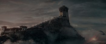 Movie still from “Fantastic Beasts: The Secrets of Dumbledore” (2022), directed by David Yates – A dark picture of a lighthouse on a cliff; Extreme Wide shot, Low angle