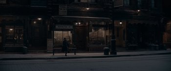 Movie still from “Fantastic Beasts: The Secrets of Dumbledore” (2022), directed by David Yates – A woman walking down a street at night; Extreme Wide shot, High angle