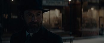 Movie still from “Fantastic Beasts: The Secrets of Dumbledore” (2022), directed by David Yates – A man with a beard wearing a hat and a suit; Close Up shot, Over the shoulder angle