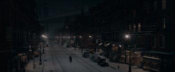 Movie still from “Fantastic Beasts: The Secrets of Dumbledore” (2022), directed by David Yates – A man is walking down a snowy street at night; Extreme Wide shot, High angle