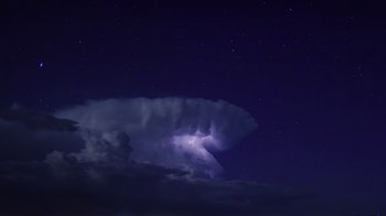 Movie still from “Fantastic Fungi” (2019), directed by Louie Schwartzberg – A cloud with a purple light shining on it; Extreme Wide shot, Low angle
