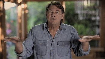 Movie still from “Fantastic Fungi” (2019), directed by Louie Schwartzberg – A man in a blue shirt is standing in front of a window; Medium shot, Low angle
