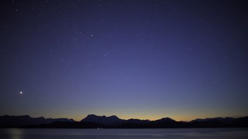 Movie still from “Fantastic Fungi” (2019), directed by Louie Schwartzberg – A night sky filled with stars over a body of water; Extreme Wide shot, Low angle