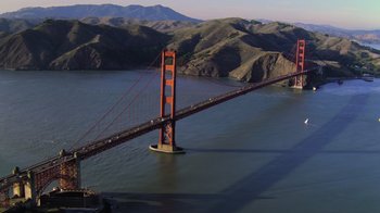 Movie still from “Fantastic Fungi” (2019), directed by Louie Schwartzberg – A view of the golden gate bridge from a helicopter; Extreme Wide shot, High angle