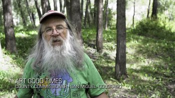 Movie still from “Fantastic Fungi” (2019), directed by Louie Schwartzberg – An old man with a beard and glasses in a forest; Medium shot, Over the shoulder angle