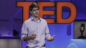 Movie still from “Fantastic Fungi” (2019), directed by Louie Schwartzberg – A man standing in front of a ted logo; Medium shot, Overhead angle