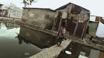 Movie still from “Fantastic Fungi” (2019), directed by Louie Schwartzberg – A little girl walking across a bridge over a river; Wide shot, High angle