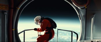 A man in a spacesuit is climbing up a ladder