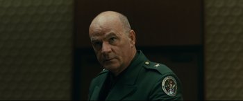 Movie still from “Ad Astra” (2019), directed by James Gray – A man in a uniform is looking at the camera; Close Up shot, Low angle