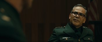 Movie still from “Ad Astra” (2019), directed by James Gray – A man in a green military uniform sitting in front of a wall; Close Up shot, Over the shoulder angle