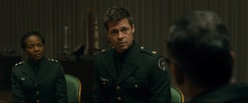 Movie still from “Ad Astra” (2019), directed by James Gray – A man in a military uniform sitting in a chair; Medium shot, Over the shoulder angle