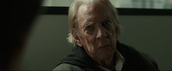 Movie still from “Ad Astra” (2019), directed by James Gray – An old man with white hair is looking at the camera; Close Up shot, Low angle